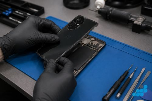 celltech technician removing a OnePlus back panel before battery replacement