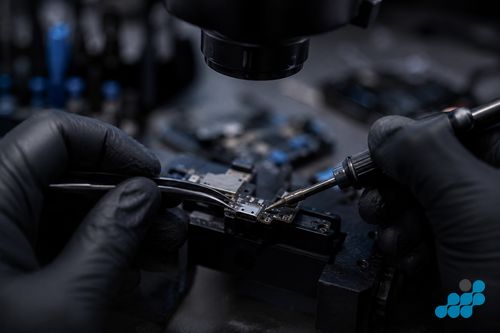 celltech technician micro-soldering a USB-C port onto a OnePlus motherboard