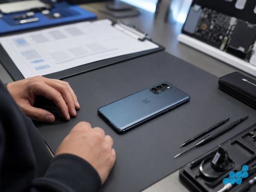Repaired OnePlus phone on the celltech workbench with repair documentation